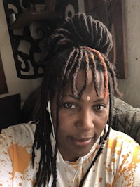 a woman with dreadlocks sitting on a couch