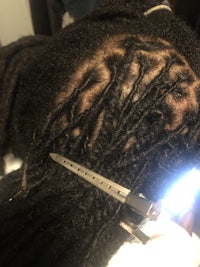 a woman's hair is being cut with scissors