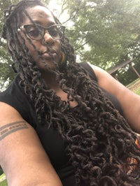 a woman with long dreadlocks and glasses