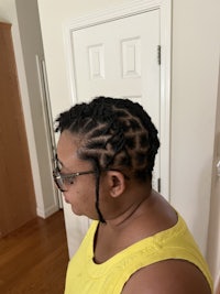 a woman in a yellow shirt with dreadlocks in her hair