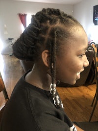 a girl with dreadlocks sitting in a chair