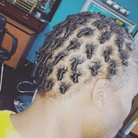 a man with dreadlocks in his hair at a barber shop