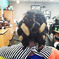 the back of a woman with dreadlocks in a salon