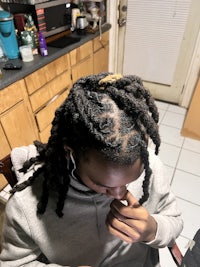 a girl with dreadlocks sitting in a chair