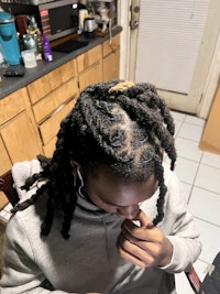 a girl with dreadlocks sitting in a chair